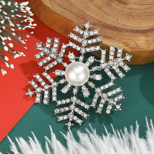 Elegant snowflake pearl brooch with rhinestones for women in a festive winter setting
