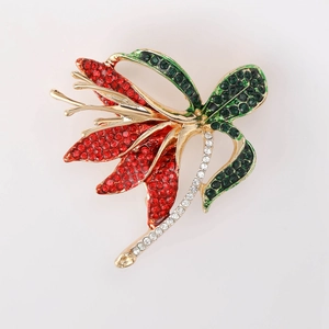 Close-up of elegant narcissus brooch with vibrant red, green, and white rhinestones