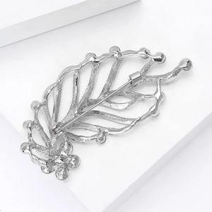 Detailed back view of silver rhinestone leaf brooch with secure safety pin closure