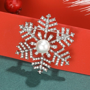 Snowflake brooch with white pearls and sparkling rhinestones on festive background