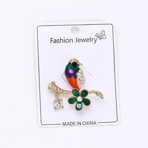 Detail of colorful alloy pigeon brooch with sparkling rhinestones and floral enamel finish