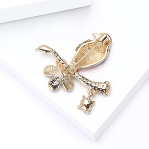 Golden alloy pigeon brooch with textured floral back view and star pendant detail