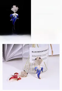 Détail macro d'une broche poisson rouge avec strass brillants et queue émaillée