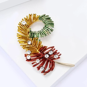 Elegant feather brooch with gradient metal plating and sparkling crystals on white background