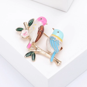 Exquise broche d'oiseaux en émail avec deux oiseaux colorés sur une branche dorée sur socle