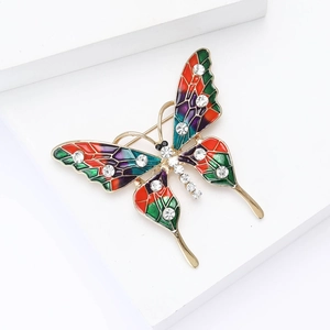 Broche papillon élégante avec émail coloré et strass scintillants sur une monture dorée