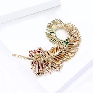 Detail of multi-color enamel feather brooch with gold plating and secure rotating safety pin
