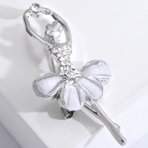 Macro della spilla ballerina in argento con strass bianchi e dettagli della gonna perlata
