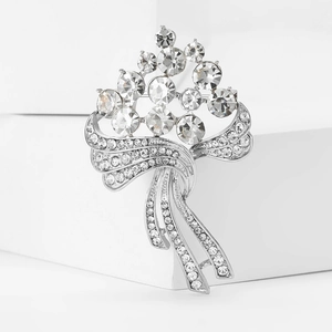 Broche bouquet de fleurs argentée ornée de cristaux scintillants et de rubans glands