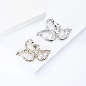 Elegant double swan brooch with rhinestones and white pearls in gold and silver finish