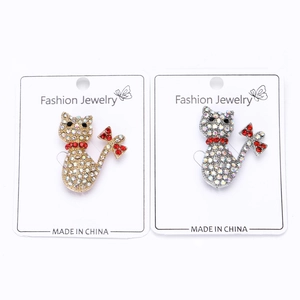 Detailed view of hollow cat brooches with crystals and pearls in gold and silver finish
