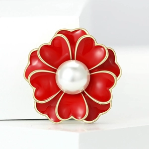 Elegante broche de flor de peonia roja con pétalos dorados y perla blanca en base blanca