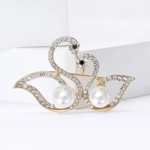Elegant gold-tone twin swan brooch with white pearls and sparkling crystal rhinestones