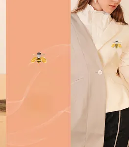 Detail of bee brooch with yellow enamel wings and white rhinestones on suit jacket