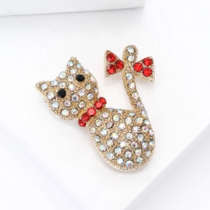 Close-up of golden cat brooch with colorful AB rhinestones and red bow detail