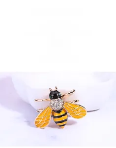 Macro detail of enamel honey bee brooch with yellow wings and sparkling rhinestones