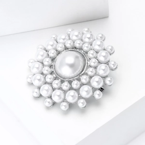 Gros plan sur une grande broche en perles avec trois couches de perles sur base argent