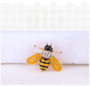 Close-up of golden honey bee brooch with black yellow enamel and sparkling rhinestones