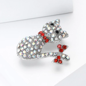 Macro shot of silver cat brooch with iridescent crystals and red bow detail