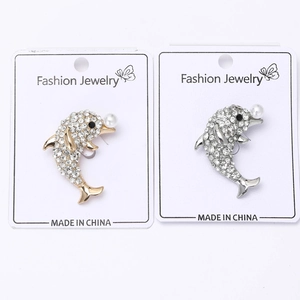 Détails des broches dauphin en argent et or avec des strass et des perles blanches