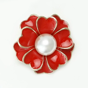 Detalle del broche de flor de esmalte rojo con perla y bordes de pétalos dorados