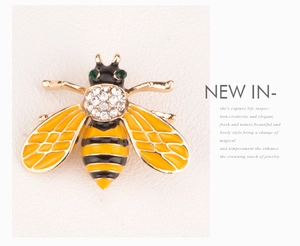 Macro shot of bee brooch with yellow enamel wings and sparkling crystal details