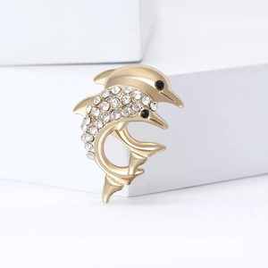 Élégante broche dauphin dorée ornée de strass brillants sur un support géométrique
