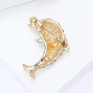 Détail du dos d'une broche dauphin avec fermoir doré et incrustations de petits strass