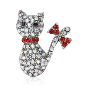 Exquisite cat brooch with shimmering AB rhinestones and a red bow detail on white background