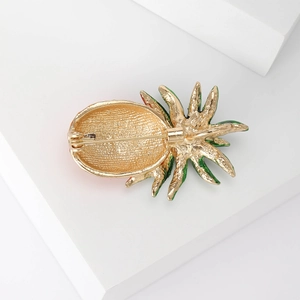 Back view of a gold plated pineapple brooch with green enamel and secure safety pin clasp