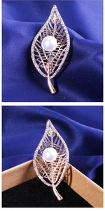 Detailed macro view of rose gold leaf brooch with white pearls and sparkling rhinestones