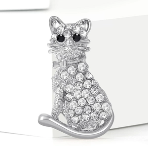 Détail macro de broche chat argentée avec incrustation de strass étincelants
