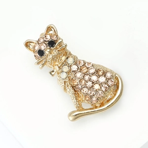 Détail d'une broche chat dorée avec strass champagne et pierre d'accent blanche brillante