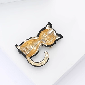 Detailed back view of cat brooch featuring gold textured metal and secure safety pin clasp