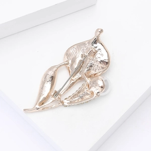 Détail de la broche feuille dorée avec perle blanche et fermoir à épingle de sécurité