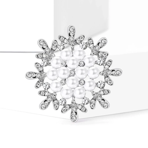 Elegant snowflake brooch with white pearls and sparkling rhinestones on a silver base