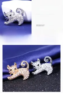 Vue détaillée des broches chat en finitions argent et or ornées de strass blancs brillants