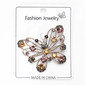 Detailed close-up of a butterfly brooch with rhinestones on a fashion jewelry card