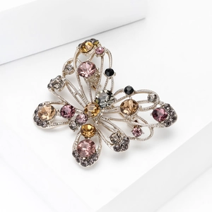 Elegant butterfly brooch with colorful rhinestones on a minimalist white display base