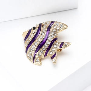 Detailed close-up of a gold-plated tropical fish brooch with purple enamel and rhinestones