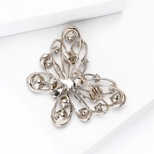 Elegant butterfly brooch in golden alloy with white rhinestones and a horizontal pin back