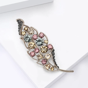 Elegant leaf-shaped alloy brooch with multi-colored rhinestones on white platform