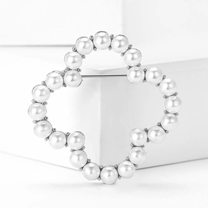 Detail view of flower brooch with pearls and crystals on geometric display stand