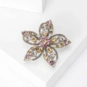 Detail of silver alloy hollow flower brooch with pink and champagne rhinestones