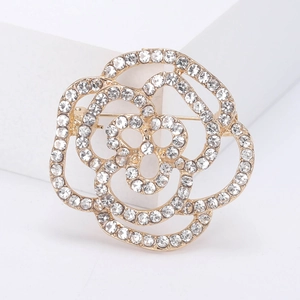 Elegante spilla a fiore dorato con strass in cristallo bianco su piedistallo