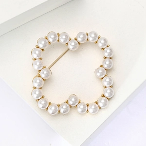 Elegant four-leaf clover brooch with white pearls and gold alloy finish on white background