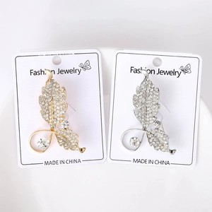 Détail de broches feuilles avec strass et perles sur leur support de présentation