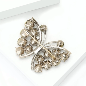 Detailed back view of butterfly brooch showing pin fastener and alloy stone settings