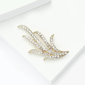 Détail de l'élégante broche feuille de narcisse en or avec cristaux strass brillants