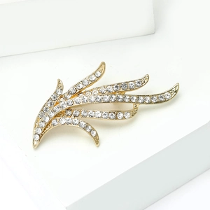 Vue macro détaillée d'une broche jonquille dorée avec strass sur un socle blanc minimaliste